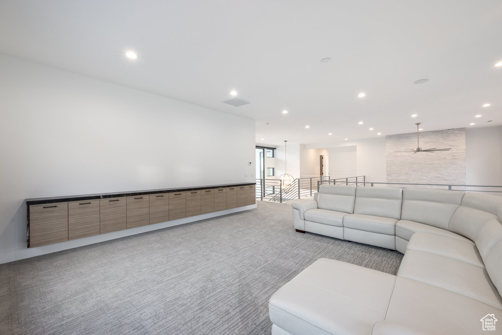 Living room with light colored carpet, recessed lighting, and a ceiling fan