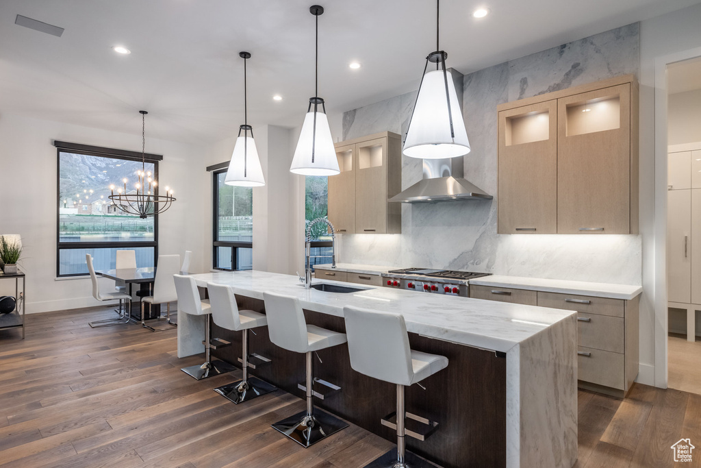 Kitchen with dark wood finished floors, backsplash, a center island with sink, recessed lighting, and light brown cabinetry