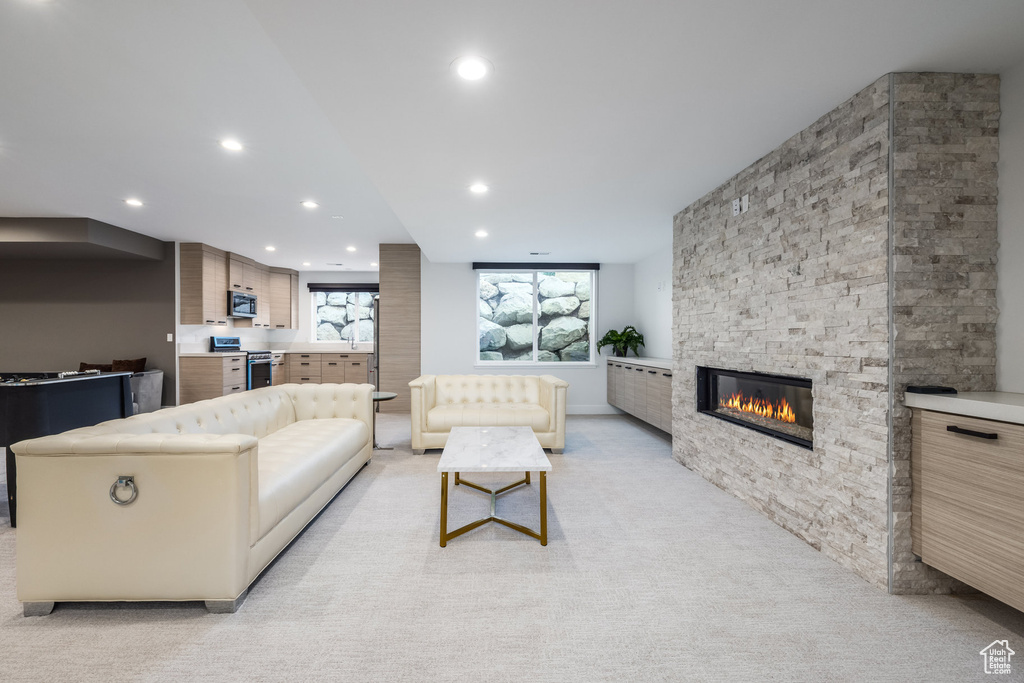Living room with recessed lighting, a fireplace, and light carpet