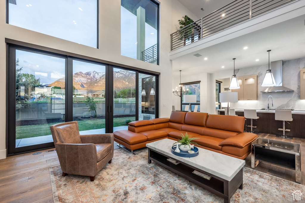 Living room featuring light wood-style floors, recessed lighting, and a towering ceiling