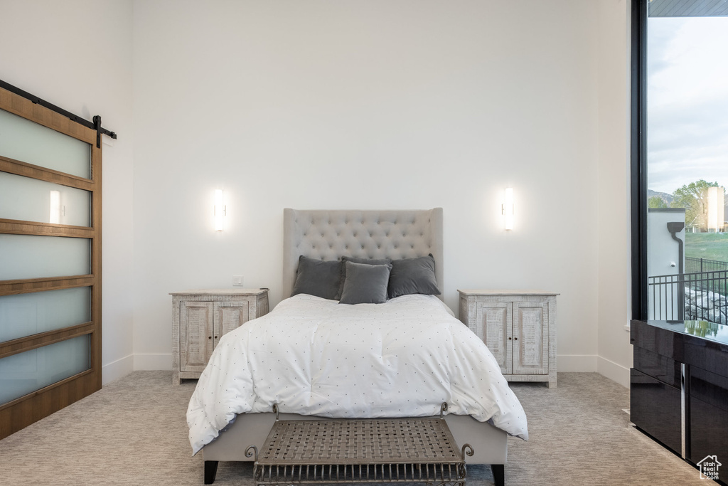 Bedroom with carpet, a barn door, and baseboards