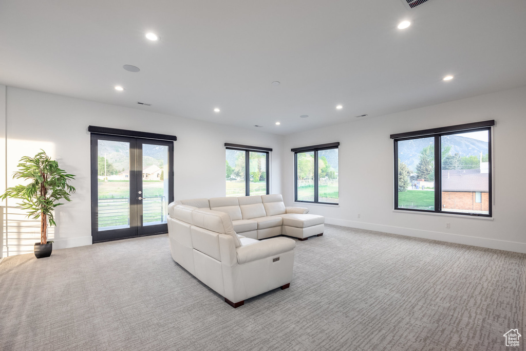 Living area featuring light carpet, recessed lighting, baseboards, french doors, and plenty of natural light