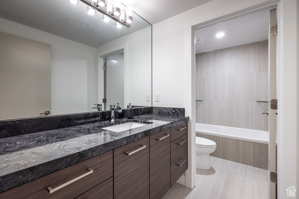 Bathroom with toilet, a tub, vanity, and a shower