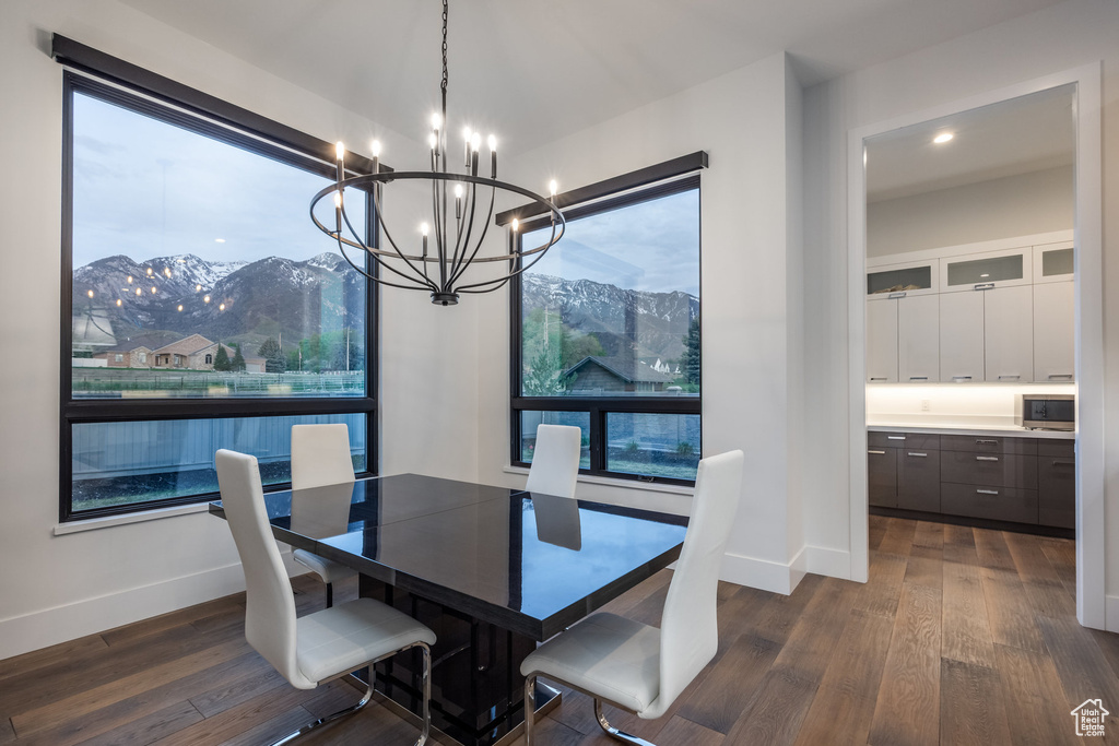 Dining space with a chandelier, dark wood-style flooring, baseboards, a mountain view, and recessed lighting