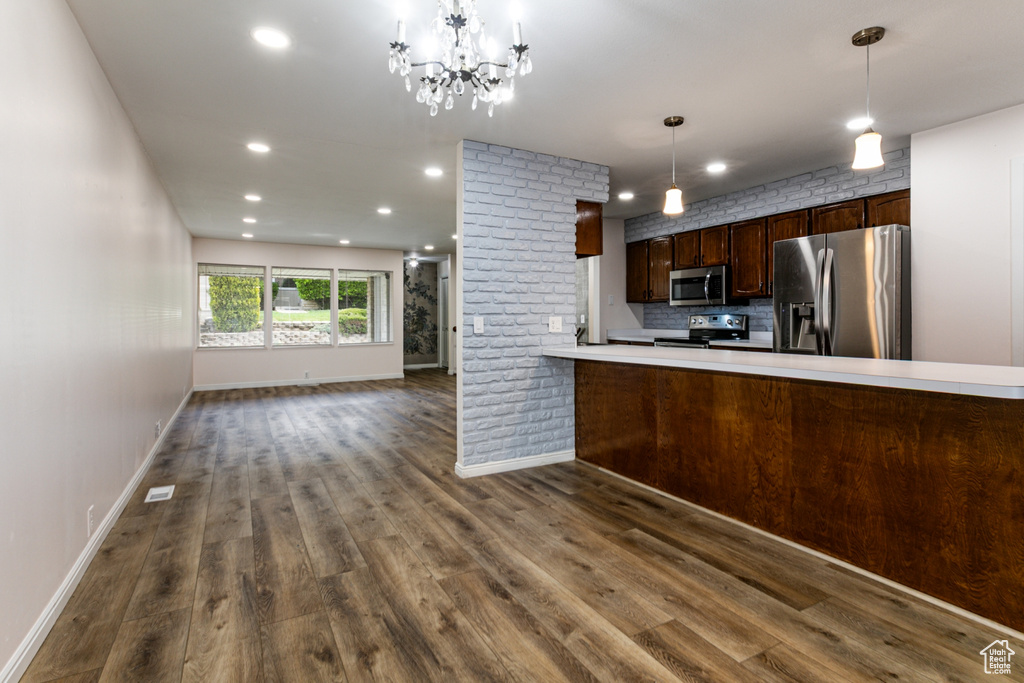 Kitchen featuring appliances with stainless steel finishes, dark wood-type flooring, baseboards, recessed lighting, and light countertops