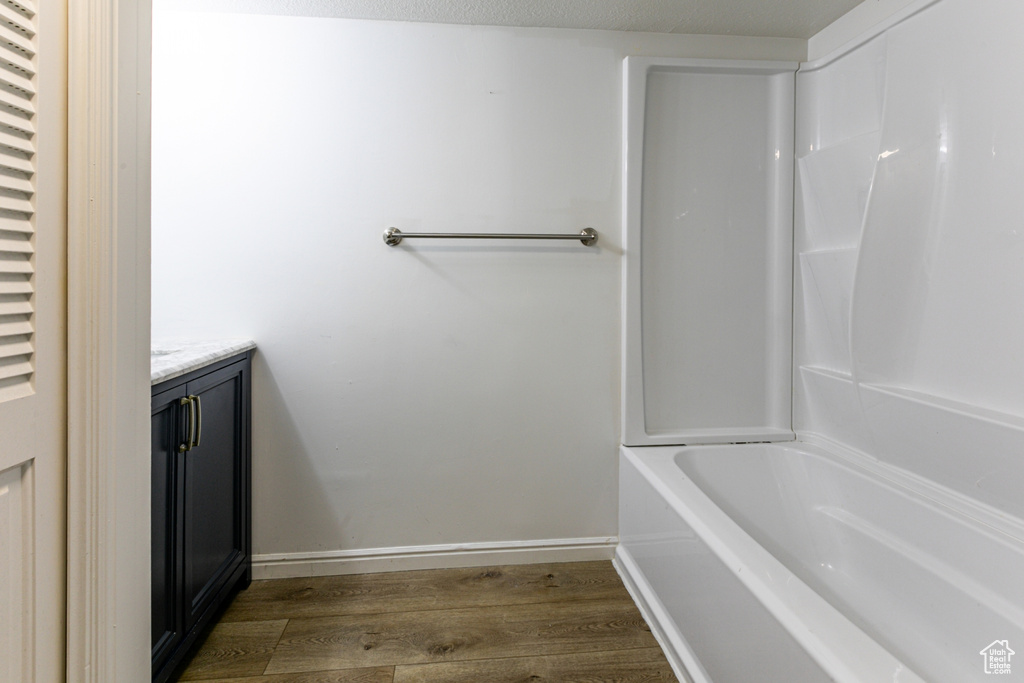 Bathroom with wood finished floors, vanity, and baseboards