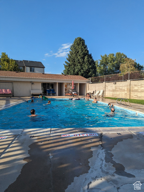 Community pool featuring fence and a patio area