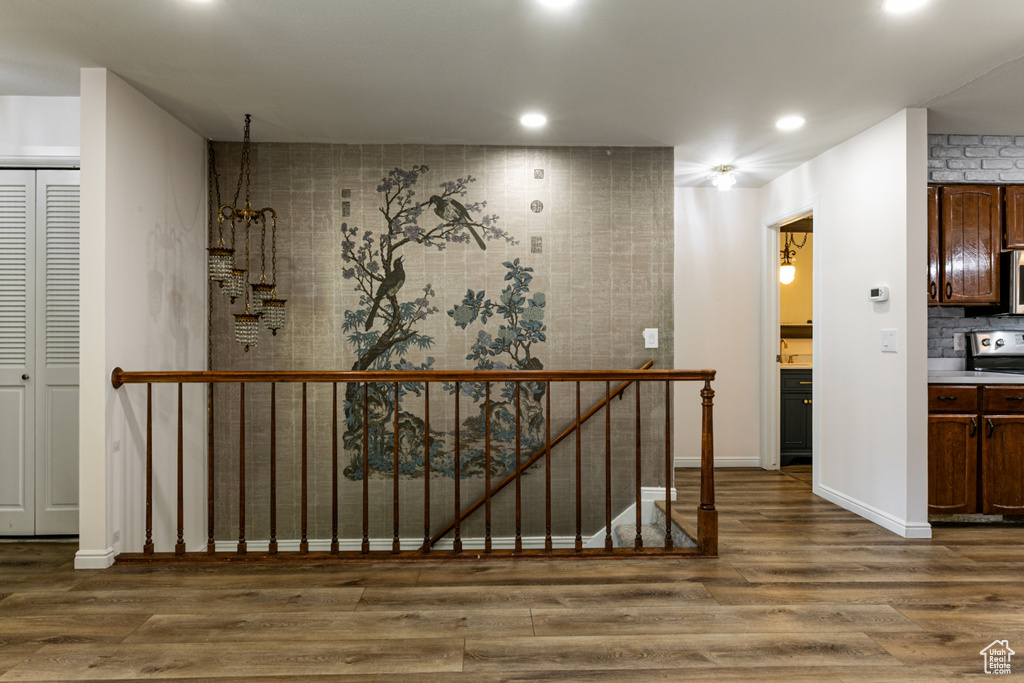 Corridor with wood finished floors, baseboards, and recessed lighting