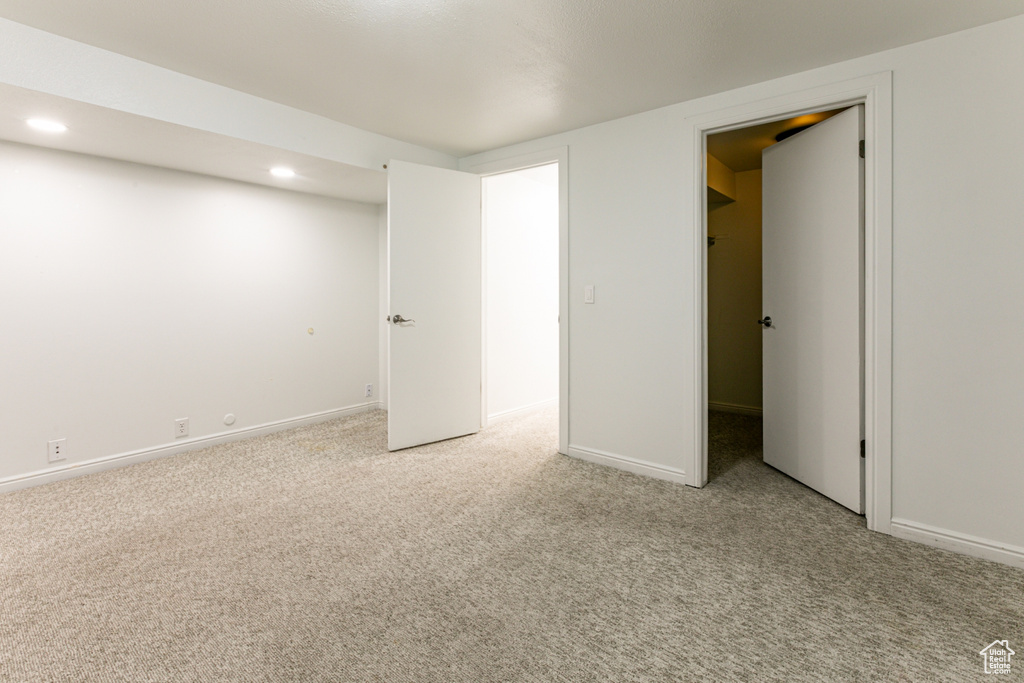 Unfurnished bedroom featuring light carpet, recessed lighting, and baseboards