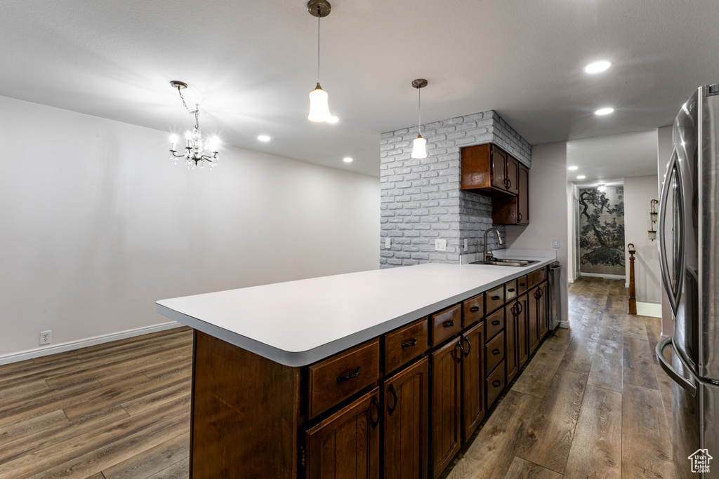 Kitchen featuring appliances with stainless steel finishes, a sink, dark wood finished floors, light countertops, and baseboards