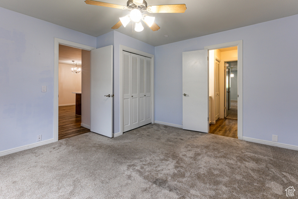 Unfurnished bedroom featuring carpet flooring, baseboards, a chandelier, and a closet