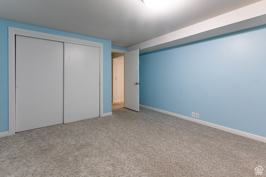 Unfurnished bedroom featuring carpet, baseboards, and a closet