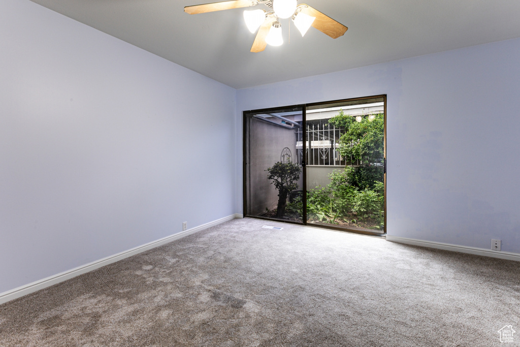 Unfurnished room with carpet, baseboards, and a ceiling fan