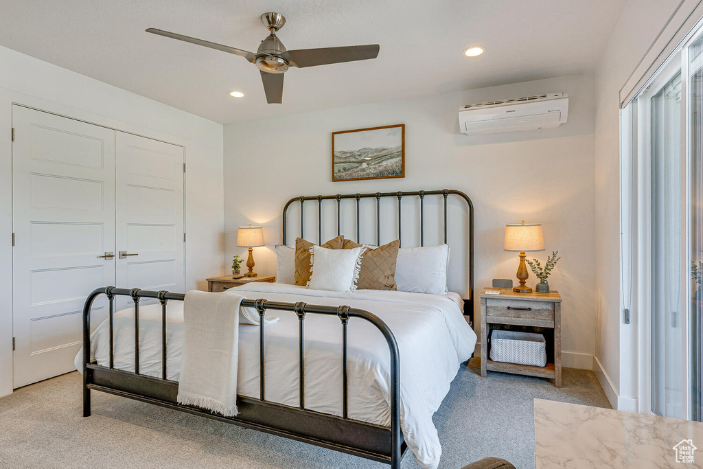 Bedroom with a wall mounted AC, light colored carpet, recessed lighting, a closet, and a ceiling fan