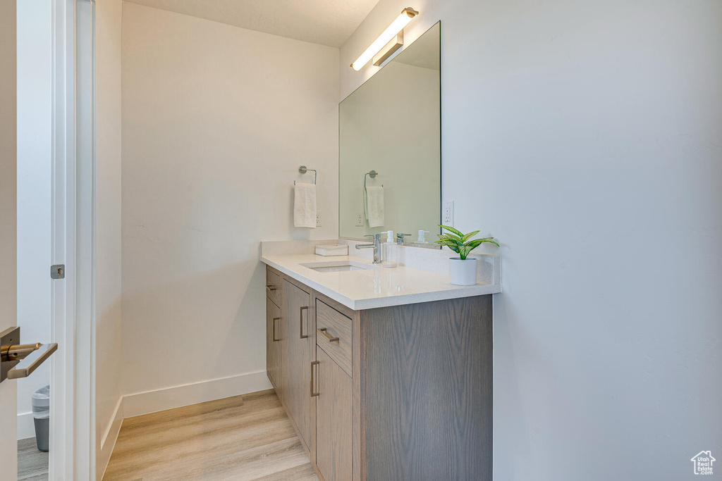 Bathroom featuring wood finished floors, vanity, and baseboards