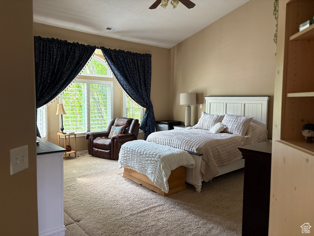Carpeted bedroom featuring a ceiling fan