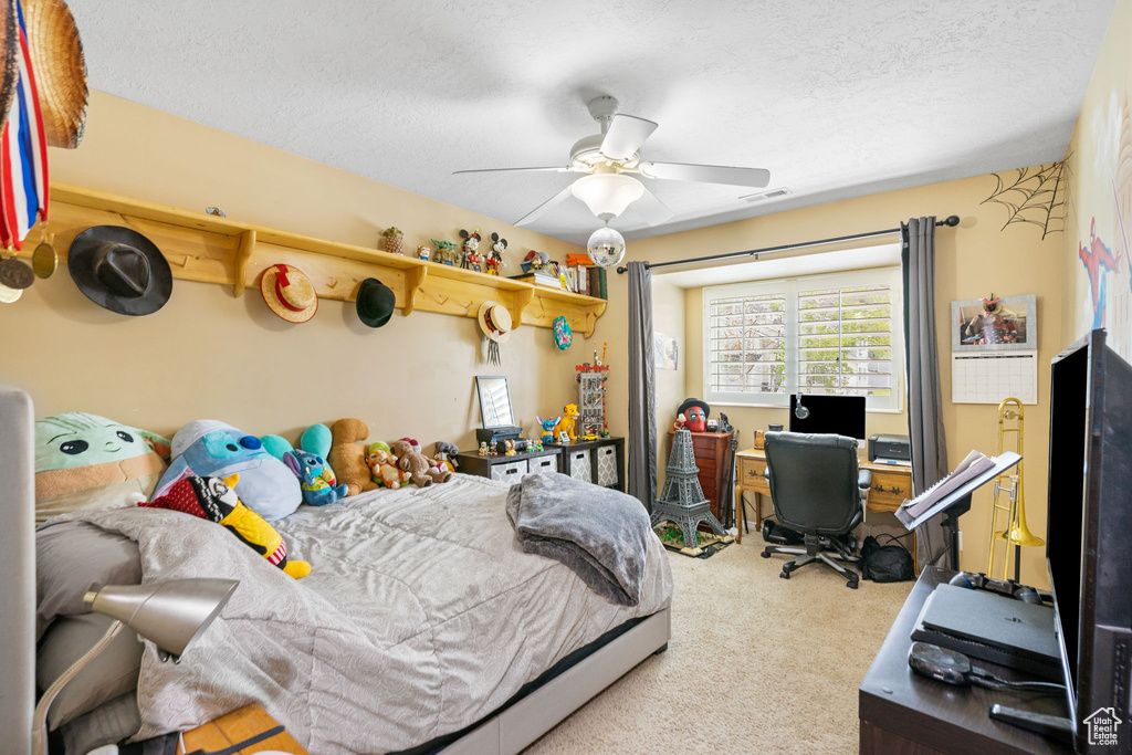 Carpeted bedroom with a textured ceiling and ceiling fan