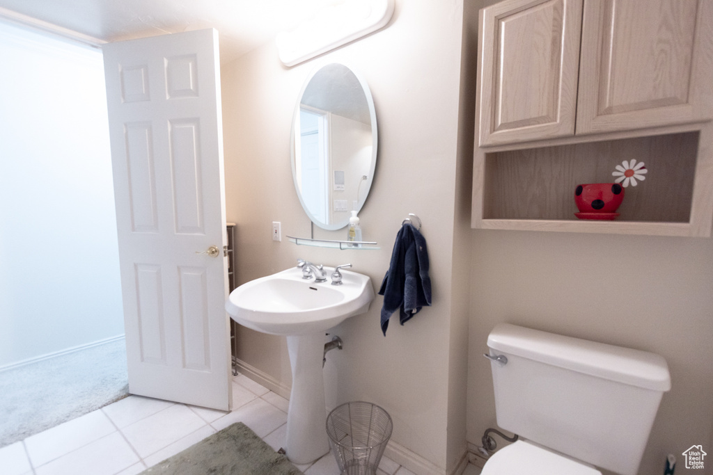 Bathroom with tile patterned flooring, toilet, and baseboards