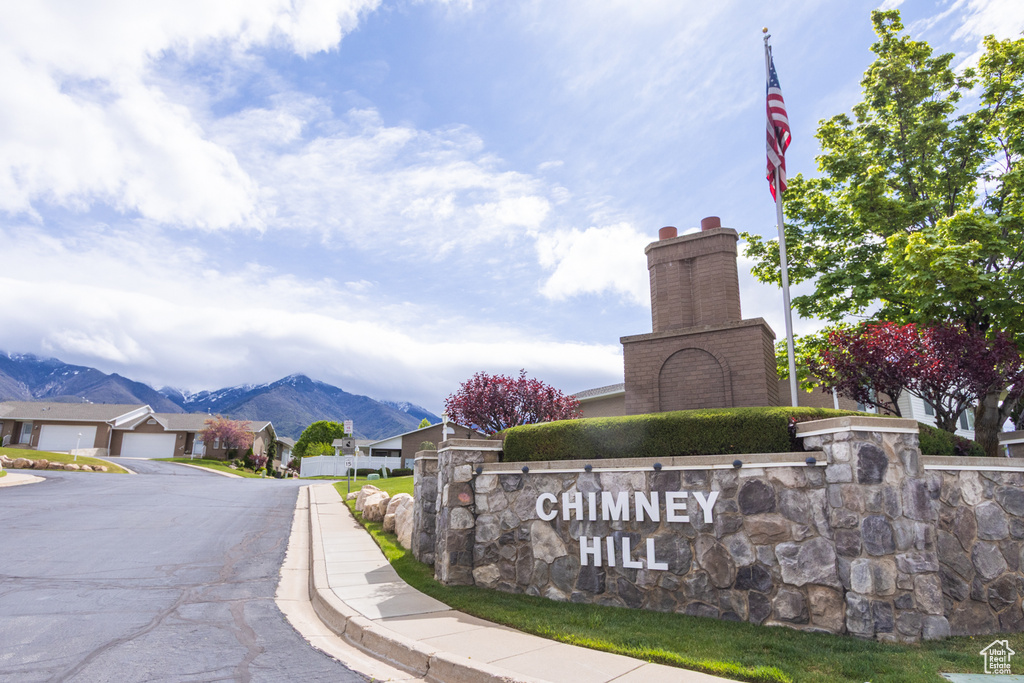Community / neighborhood sign with a mountain view and a residential view