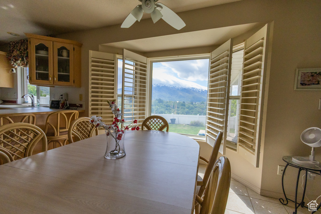 Dining room with a ceiling fan, light tile patterned floors, and baseboards