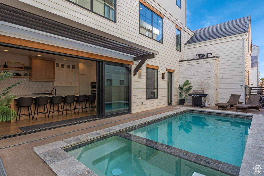 View of swimming pool featuring a patio and a pool with connected hot tub