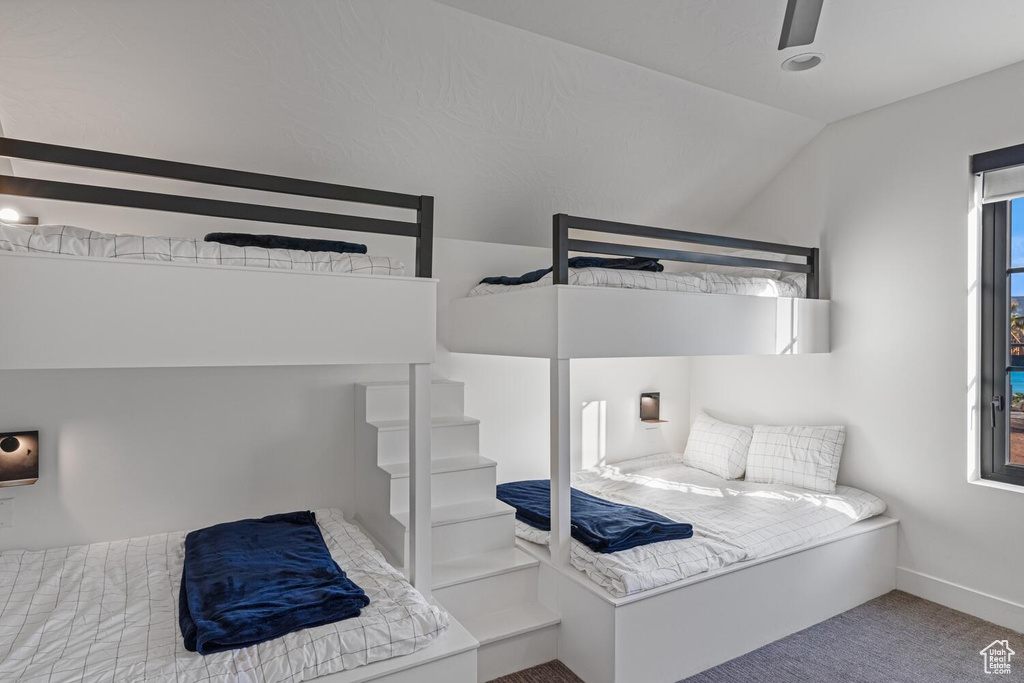 Bedroom with lofted ceiling, carpet floors, and baseboards