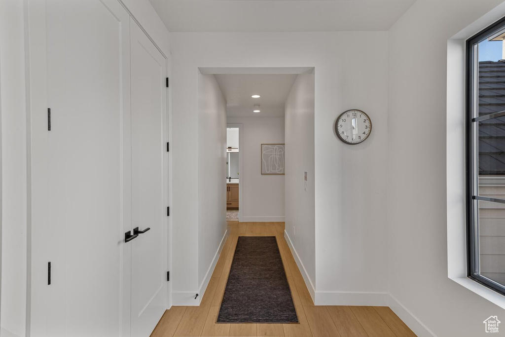 Hallway featuring light wood-style flooring, baseboards, and recessed lighting