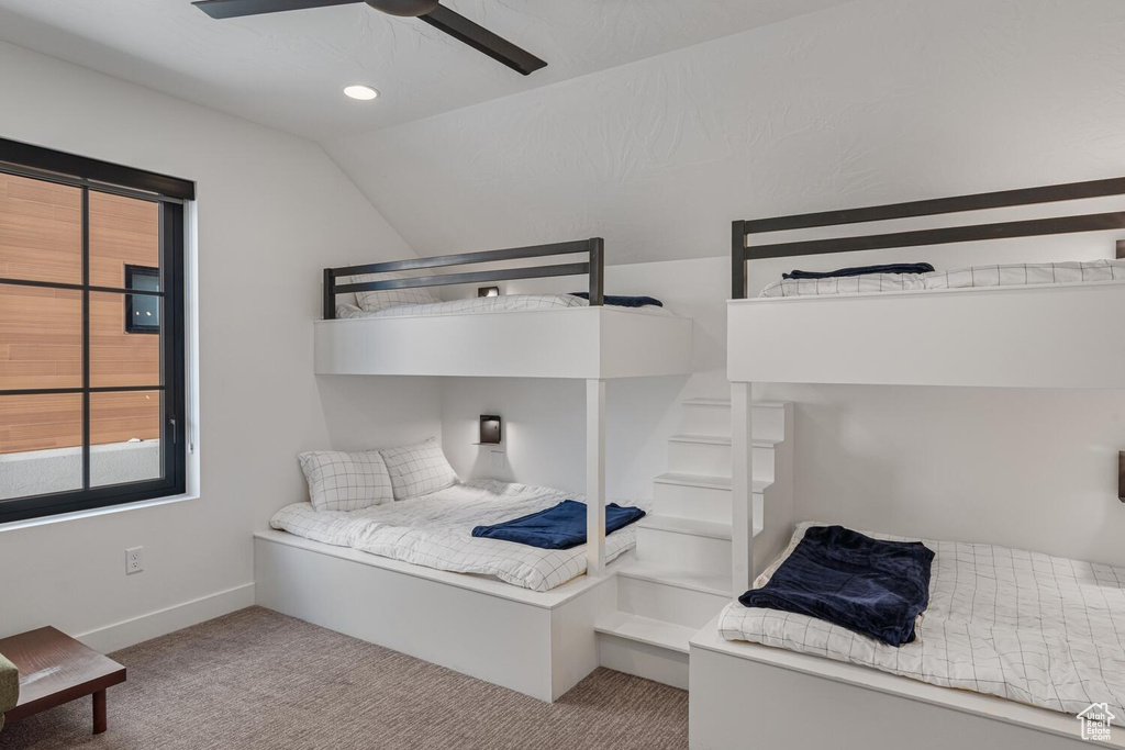 Carpeted bedroom with lofted ceiling, baseboards, recessed lighting, and a ceiling fan