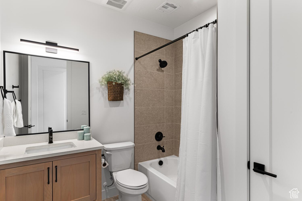 Bathroom with toilet, vanity, and shower / tub combo