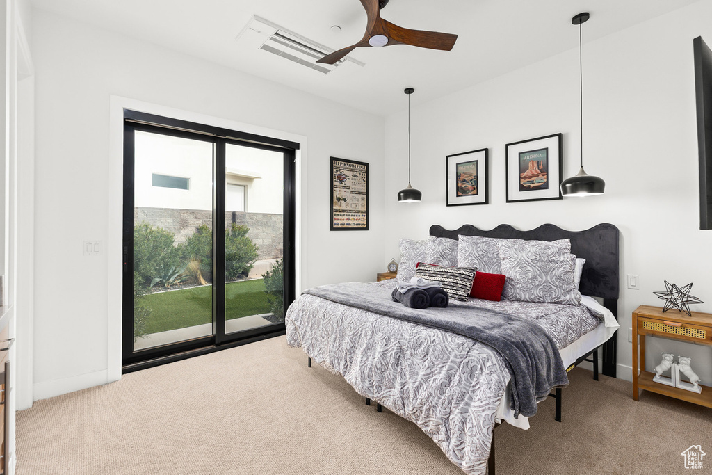 Carpeted bedroom featuring access to exterior, baseboards, and a ceiling fan