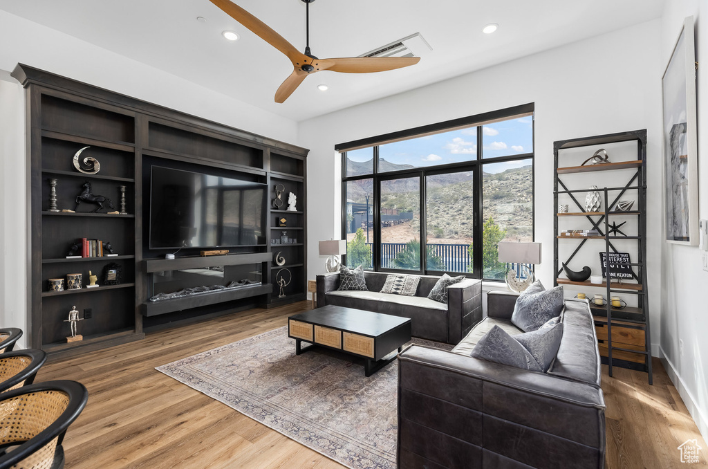 Living area featuring wood finished floors, ceiling fan, and recessed lighting