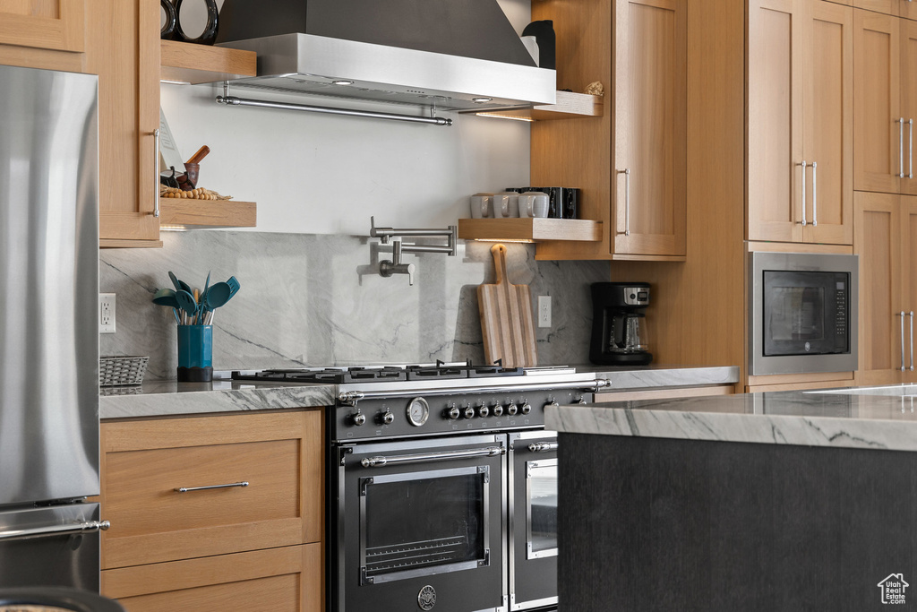 Kitchen featuring appliances with stainless steel finishes, open shelves, tasteful backsplash, and range hood