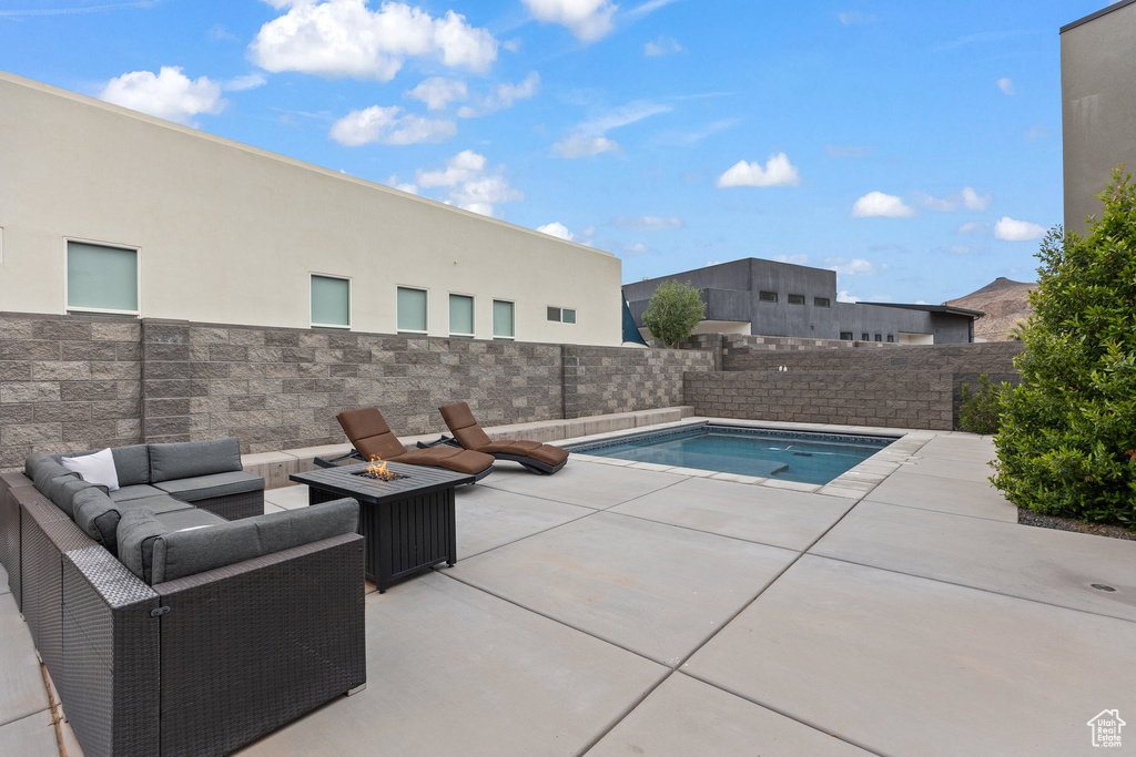 View of swimming pool with a patio area, a fenced backyard, an outdoor living space with a fire pit, and a jacuzzi