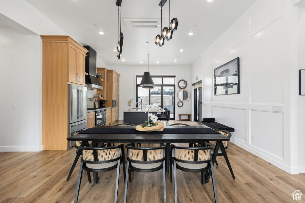 Dining area with light wood-style flooring and recessed lighting