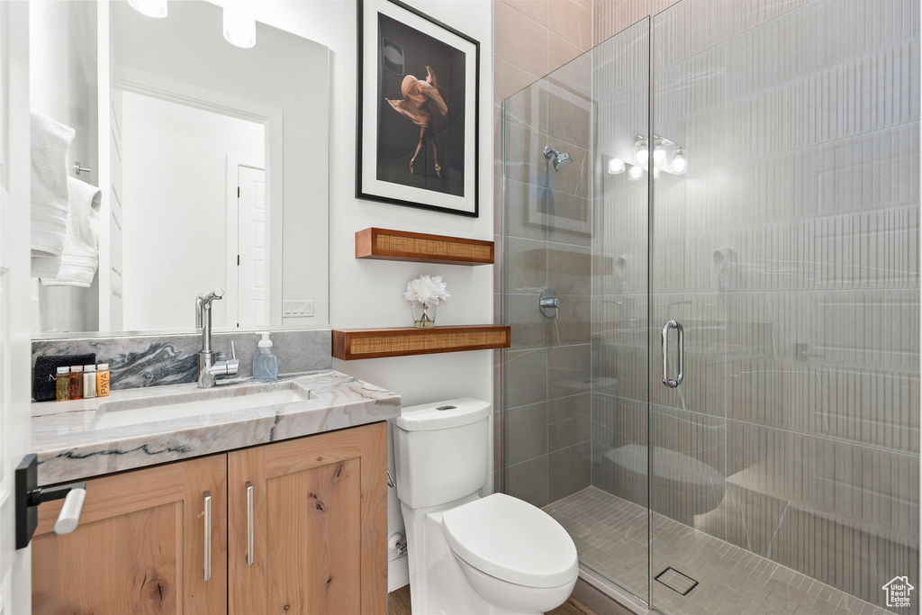 Full bath featuring toilet, a stall shower, and vanity