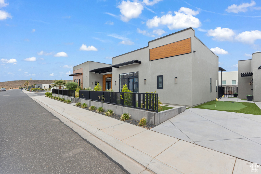 Contemporary home featuring a putting green and stucco siding