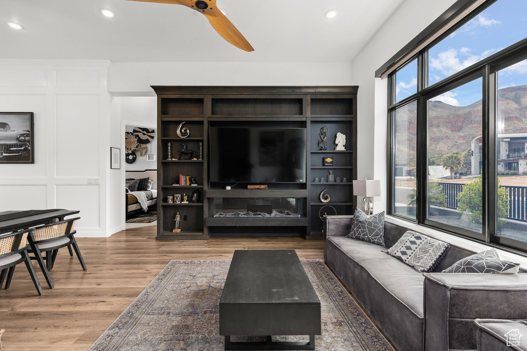 Living area featuring wood finished floors, ceiling fan, and recessed lighting