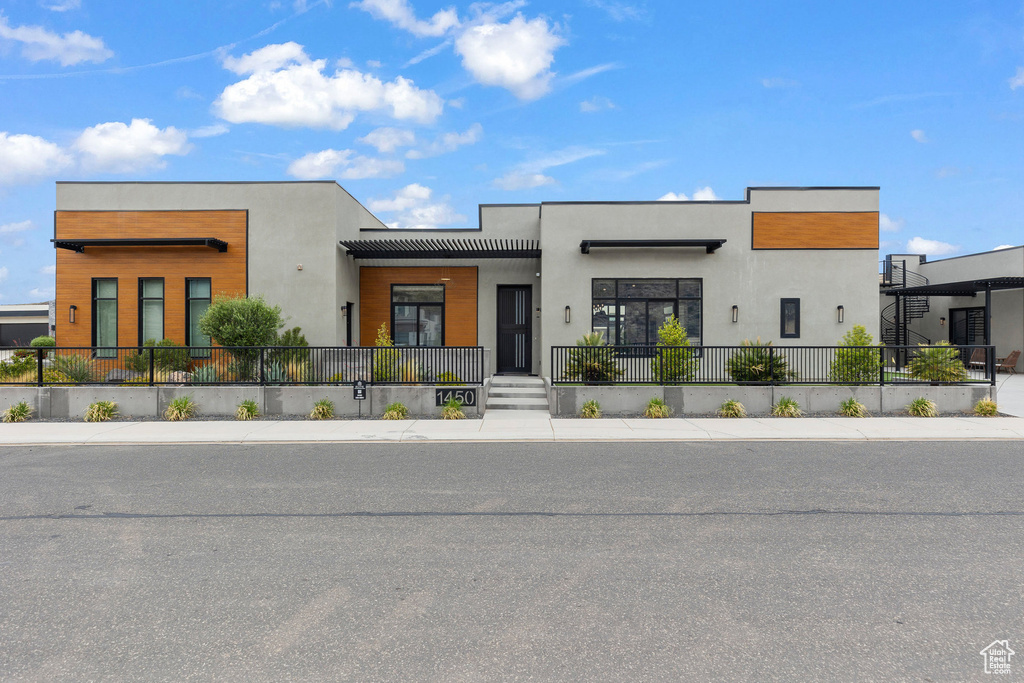 Modern home with stucco siding and fence