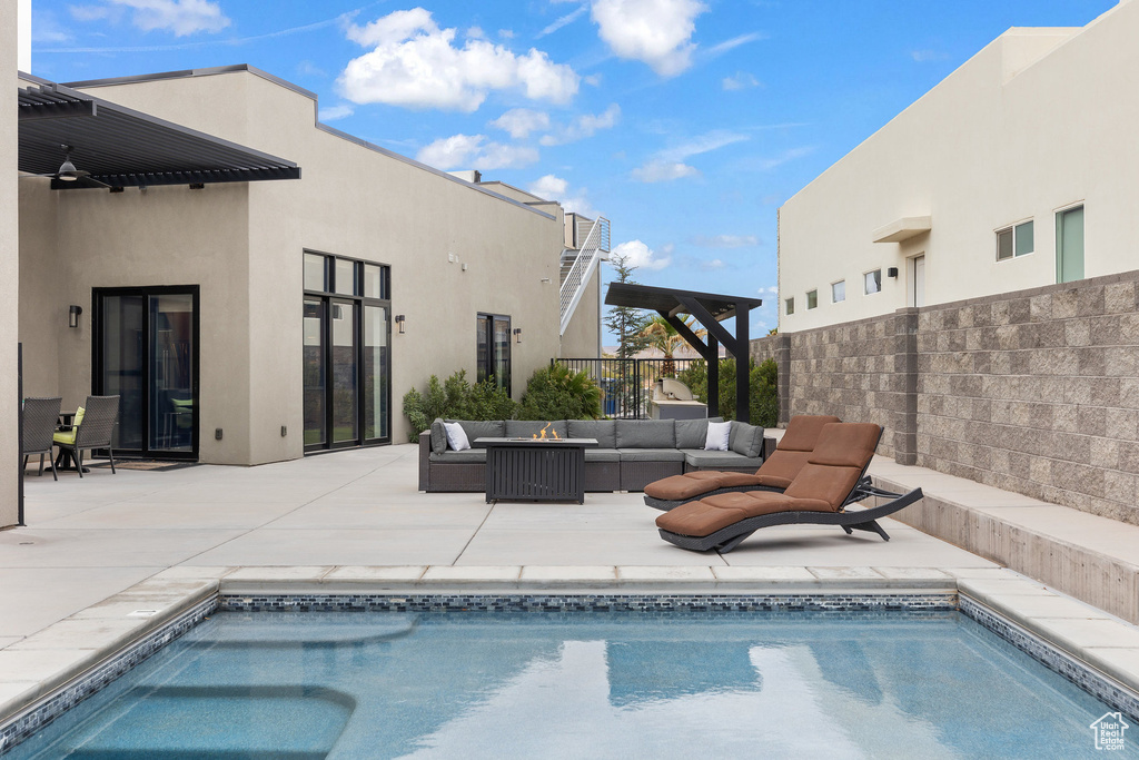 View of swimming pool with an outdoor living space, a patio area, and fence