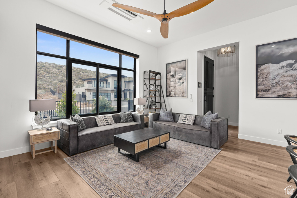 Living room with baseboards, light wood-style floors, recessed lighting, and a ceiling fan