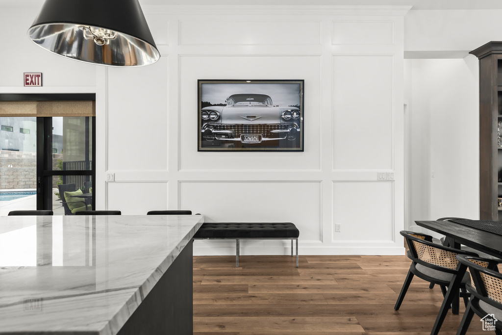 Dining room featuring a decorative wall, wood finished floors, and a chandelier