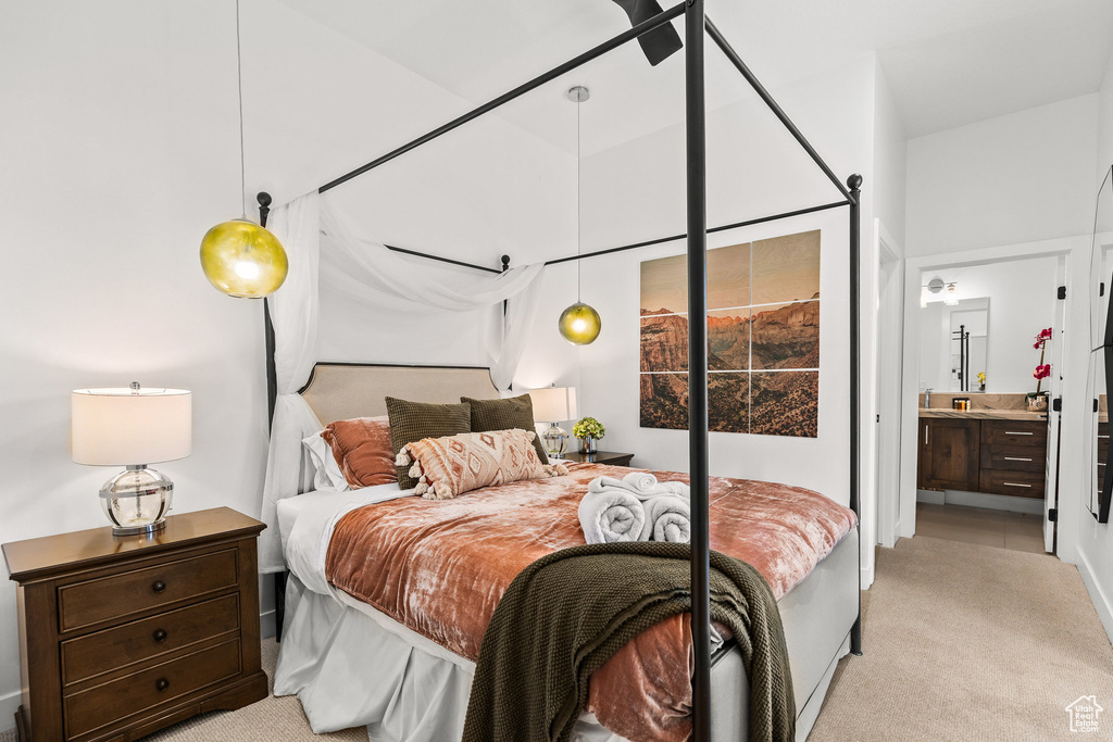 Bedroom featuring light carpet and connected bathroom