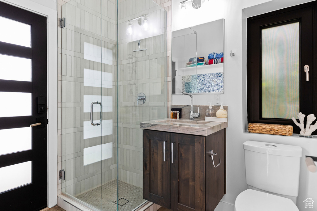 Bathroom with a stall shower, vanity, and toilet