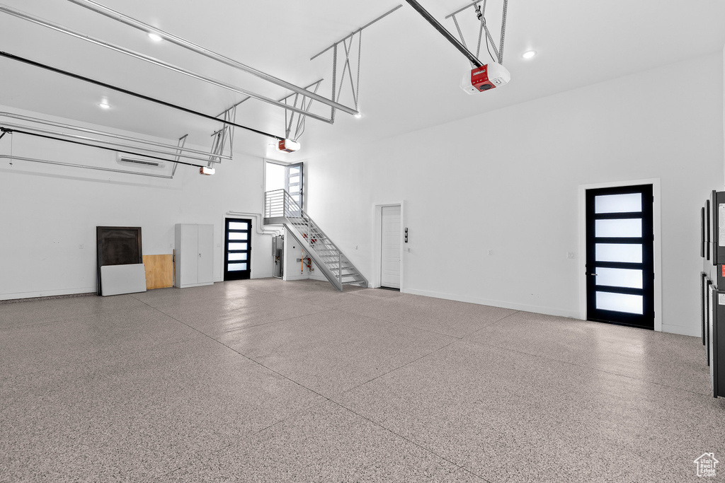 Garage featuring a garage door opener and baseboards