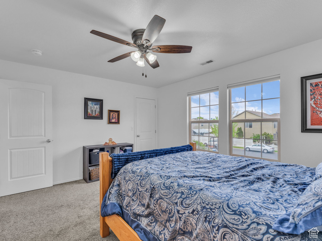 Bedroom with baseboards, a ceiling fan, visible vents, and carpet