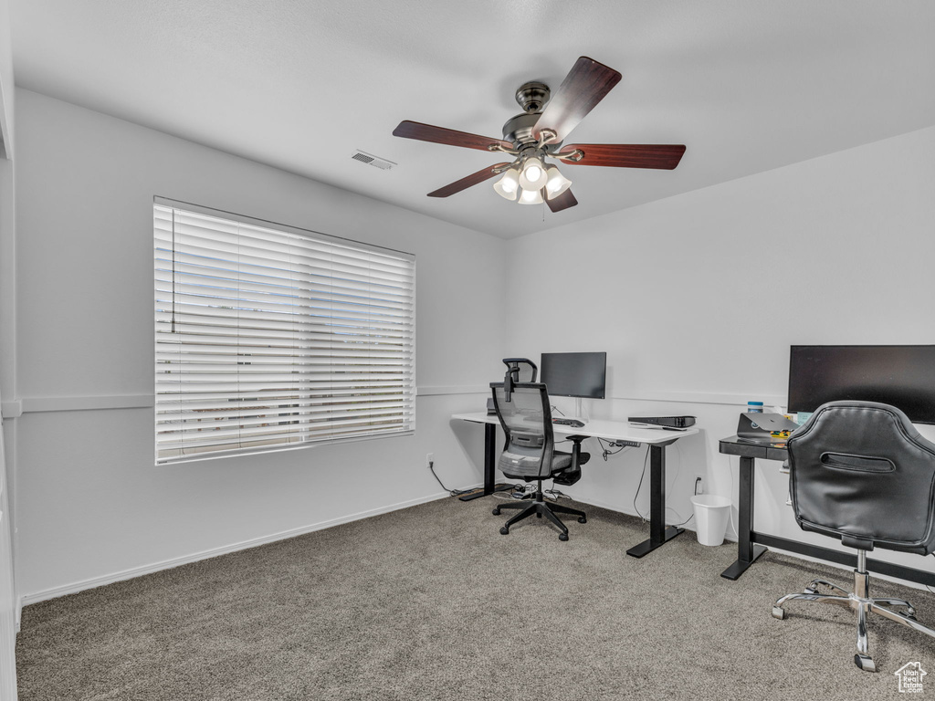 Office area with ceiling fan, plenty of natural light, visible vents, and carpet floors