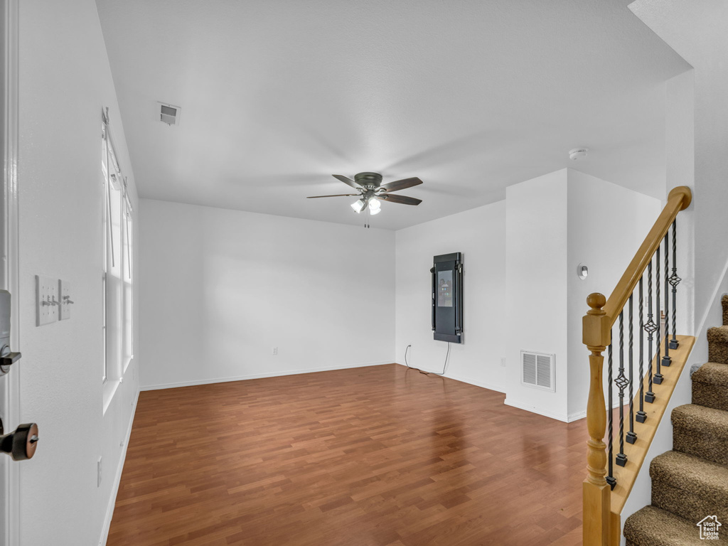 Unfurnished living room featuring visible vents, wood finished floors, and a ceiling fan