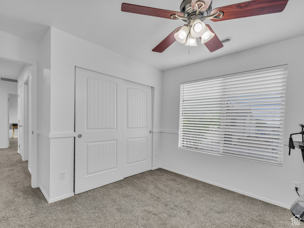 Unfurnished bedroom featuring baseboards, carpet floors, a closet, and visible vents