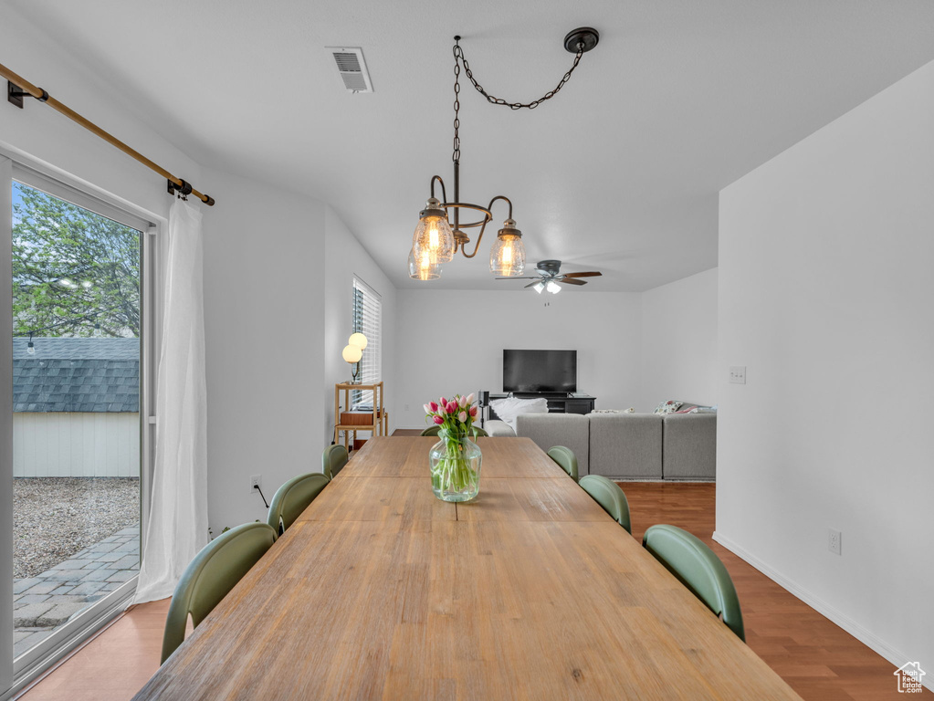 Dining room with a ceiling fan, baseboards, visible vents, and wood finished floors