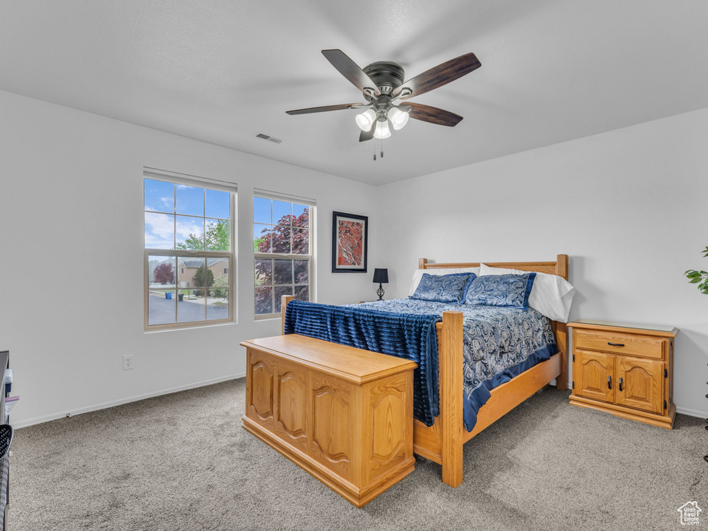 Bedroom with ceiling fan, light carpet, baseboards, and visible vents